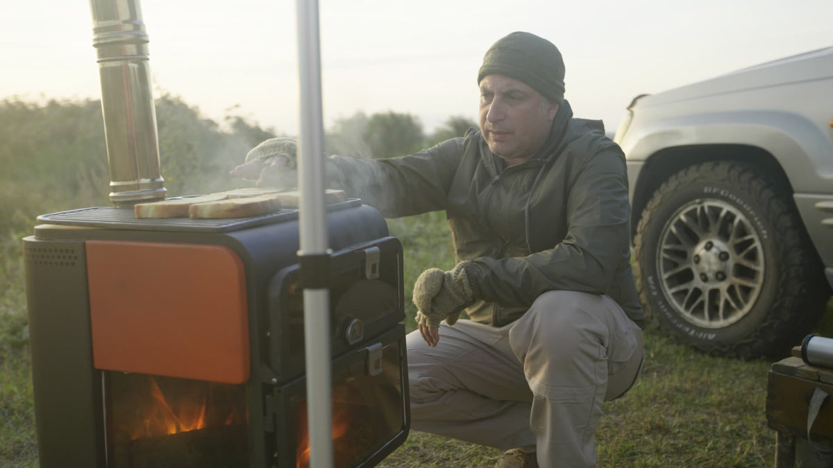 ODUN outdoor wood-fire stove in use beside an off-road vehicle